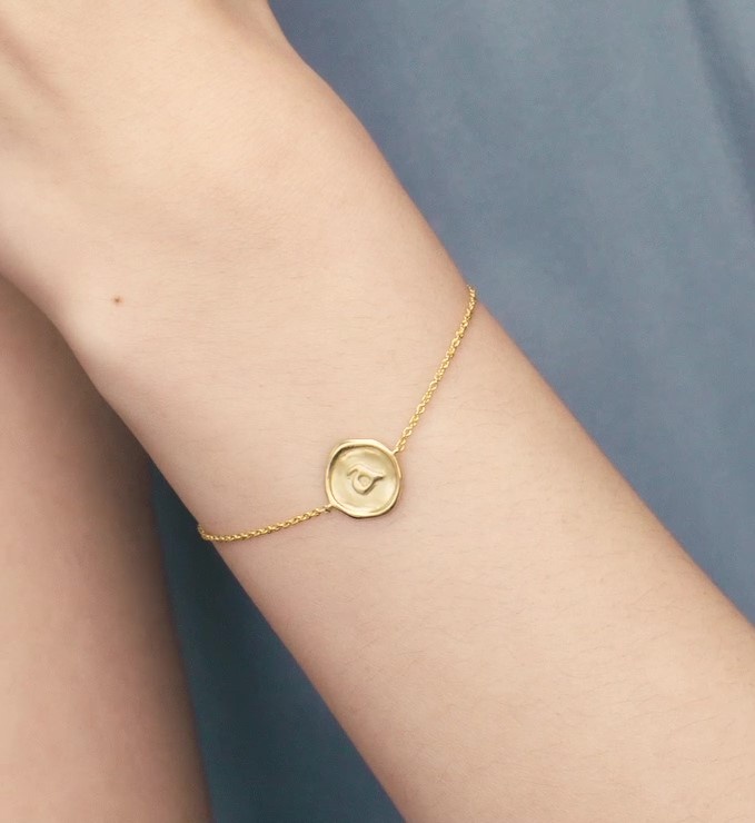 A gold vermeil chain bracelet with an 'a' letter stamp impression that looks like its cast from wax.